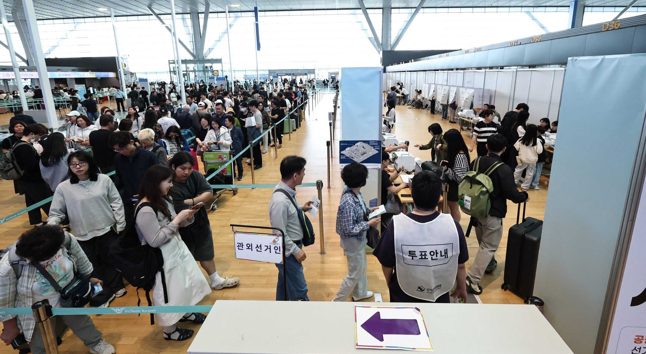 韓國選舉投票所前排隊等待投票的選民，手持身分證排隊